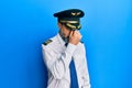 Middle age man with beard and grey hair wearing airplane pilot uniform tired rubbing nose and eyes feeling fatigue and headache Royalty Free Stock Photo