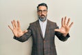 Middle age man with beard and grey hair wearing business jacket and glasses afraid and terrified with fear expression stop gesture Royalty Free Stock Photo