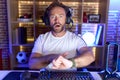 Middle age man with beard playing video games wearing headphones in hurry pointing to watch time, impatience, upset and angry for Royalty Free Stock Photo