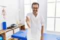 Middle age man with beard working at pain recovery clinic smiling friendly offering handshake as greeting and welcoming Royalty Free Stock Photo