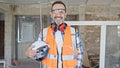 Middle age man builder smiling confident holding hardhat at construction site Royalty Free Stock Photo