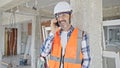 Middle age man builder smiling confident talking on smartphone at construction site Royalty Free Stock Photo