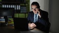 Middle age man business worker using laptop talking on smartphone at the office Royalty Free Stock Photo