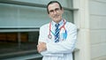 Middle age man doctor smiling confident standing with arms crossed gesture at hospital Royalty Free Stock Photo