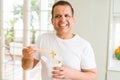 Middle age man eating take away noodles with choopsticks at home Royalty Free Stock Photo