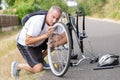 Middle-age man fixing bike outdoors