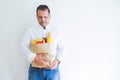 Middle age man holding groceries shopping bag over white background with a confident expression on smart face thinking serious Royalty Free Stock Photo