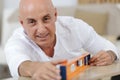 middle-age man measuring wood piece for furniture assembling Royalty Free Stock Photo