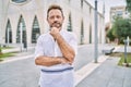 Middle age man outdoor at the city looking confident at the camera with smile with crossed arms and hand raised on chin Royalty Free Stock Photo