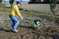 Middle age man with a rototiller Royalty Free Stock Photo