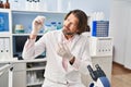 Middle age man scientist holding herb with tweezers at laboratory