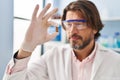 Middle age man scientist holding pill at laboratory Royalty Free Stock Photo