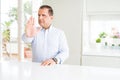 Middle age man sitting at home doing stop sing with palm of the hand Royalty Free Stock Photo