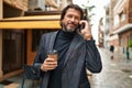 Middle age man talking on smartphone drinking coffee at street Royalty Free Stock Photo