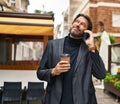 Middle age man talking on smartphone drinking coffee at street Royalty Free Stock Photo