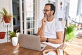 Middle age man using computer laptop at home with hand on chin thinking about question, pensive expression Royalty Free Stock Photo