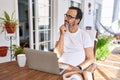 Middle age man using computer laptop at home with hand on chin thinking about question, pensive expression Royalty Free Stock Photo