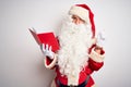 Middle age man wearing Santa Claus costume reading book over isolated white background with a big smile on face, pointing with Royalty Free Stock Photo