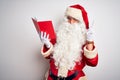 Middle age man wearing Santa Claus costume reading book over isolated white background smiling looking to the camera showing Royalty Free Stock Photo