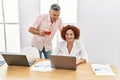 Middle age man and woman business workers drinking coffee and using laptop working at office Royalty Free Stock Photo