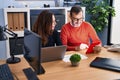 Middle age man and woman business workers using touchpad and laptop working at office Royalty Free Stock Photo