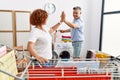 Middle age man and woman couple high five raised up hands hanging clothes at laundry Royalty Free Stock Photo