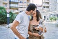 Middle age man and woman couple holding chihuahua hugging each other and kissing at street Royalty Free Stock Photo