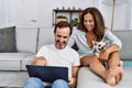 Middle age man and woman couple using laptop sitting on sofa with chihuahua at home Royalty Free Stock Photo