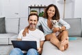 Middle age man and woman couple using laptop sitting on sofa with chihuahua at home Royalty Free Stock Photo