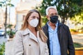 Middle age man and woman couple wearing medical mask standing at park Royalty Free Stock Photo