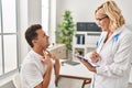 Middle age man and woman doctor and patient having medical consultation at clinic Royalty Free Stock Photo