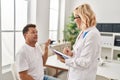 Middle age man and woman doctor and patient having medical consultation at clinic Royalty Free Stock Photo