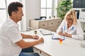 Middle age man and woman doctor and patient having medical consultation at clinic Royalty Free Stock Photo