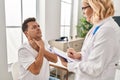 Middle age man and woman doctor and patient having medical consultation at clinic Royalty Free Stock Photo