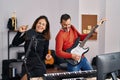 Middle age man and woman musicians playing electric guitar singing song at music studio Royalty Free Stock Photo