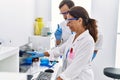 Middle age man and woman partners wearing scientist uniform working at laboratory