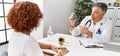 Middle age man and woman wearing doctor uniform having medical consultation holding inhaler at clinic Royalty Free Stock Photo