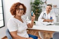 Middle age man and woman wearing doctor uniform having medical consultation holding inhaler at clinic Royalty Free Stock Photo