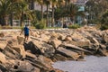 Middle age man at workout outdoors jogging along the sea at sunny day, at rocks Royalty Free Stock Photo