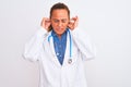 Middle age mature doctor woman wearing stethoscope over isolated background covering ears with fingers with annoyed expression for Royalty Free Stock Photo
