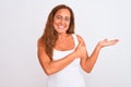 Middle age mature woman standing over white isolated background Showing palm hand and doing ok gesture with thumbs up, smiling Royalty Free Stock Photo
