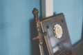 Middle age model sword and plaque on the wooden shelf