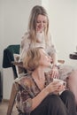 middle age mother having fun with her adult daughter drinking tea and laughing. five o& x27;clock tea at home with family