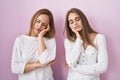 Middle age mother and young daughter standing over pink background thinking looking tired and bored with depression problems with Royalty Free Stock Photo