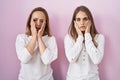 Middle age mother and young daughter standing over pink background tired hands covering face, depression and sadness, upset and Royalty Free Stock Photo