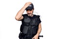 Middle age policeman wearing police uniform and bulletproof vest over white background surprised with hand on head for mistake,