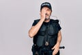 Middle age policeman wearing police uniform and bulletproof vest over white background surprised with hand on head for mistake, Royalty Free Stock Photo