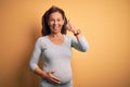 Middle age pregnant woman expecting baby at aged pregnancy doing happy thumbs up gesture with hand Royalty Free Stock Photo