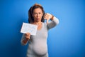 Middle Age Pregnant Woman Expecting Baby Boy Over Blue Background With Angry Face, Negative Sign Showing Dislike With Thumbs Down,