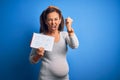 Middle age pregnant woman expecting baby boy over blue background annoyed and frustrated shouting with anger, crazy and yelling Royalty Free Stock Photo